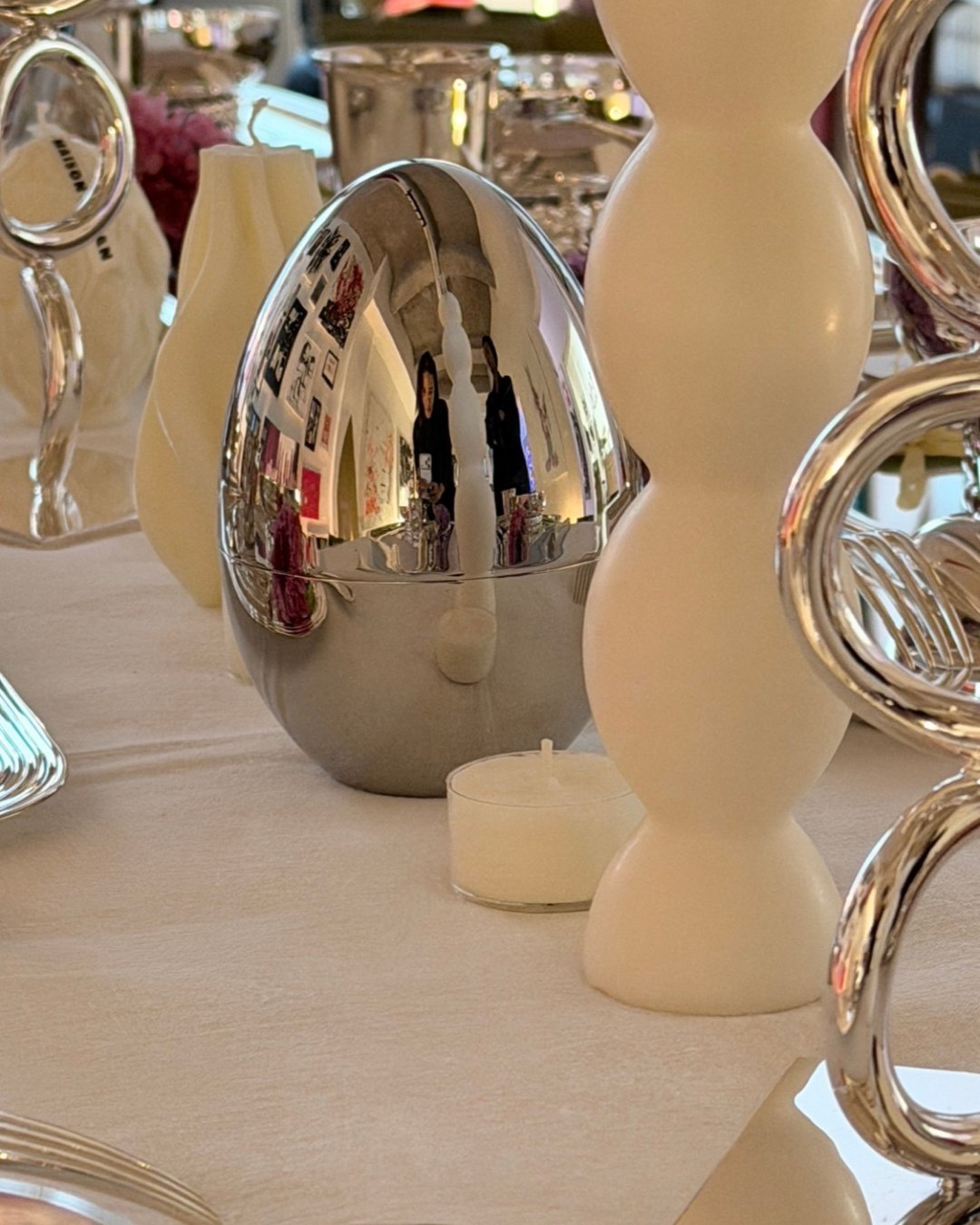 La galerie se reflétant au centre d'une pièce d'argenterie, comme dans un miroir