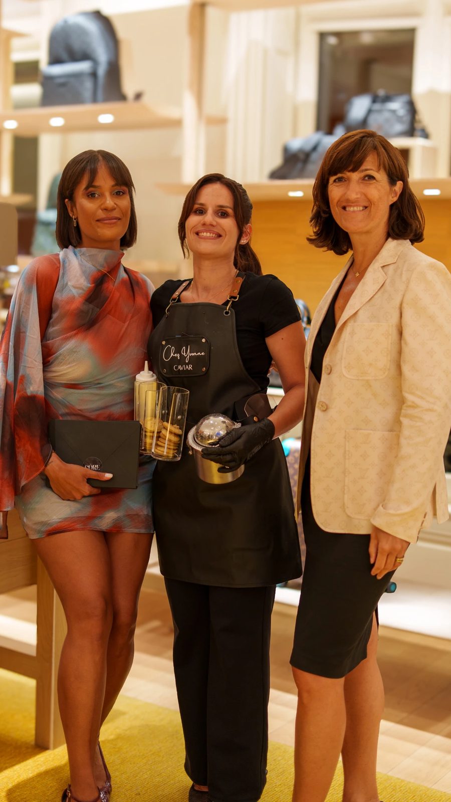 Trois invitées posant avec le coffret CŌRE et le service à caviar, au sein de la Maison Louis Vuitton